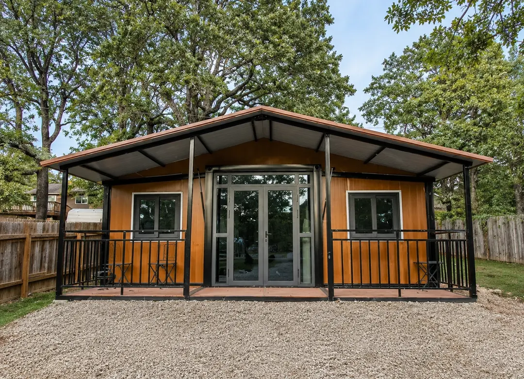 Casa modular expandible con fachada beige y azul, frente al mar